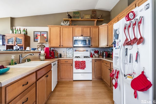 kitchen with white appliances, light wood-style flooring, light countertops, and a sink