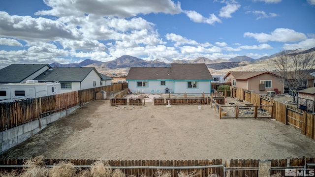 back of property with a residential view, a fenced backyard, and a mountain view