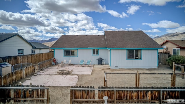 back of property featuring an outdoor fire pit, a patio area, a fenced backyard, and a mountain view