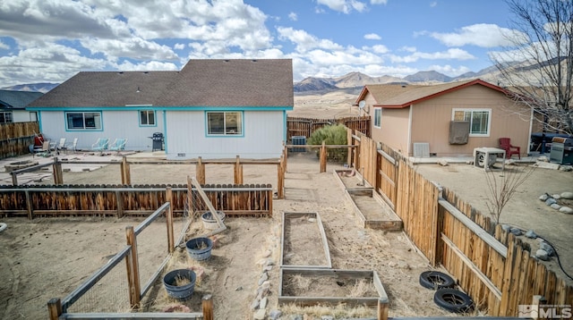 back of house featuring a vegetable garden, a fenced backyard, cooling unit, a patio area, and a mountain view