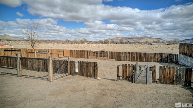 view of yard featuring a gate, fence, and a mountain view