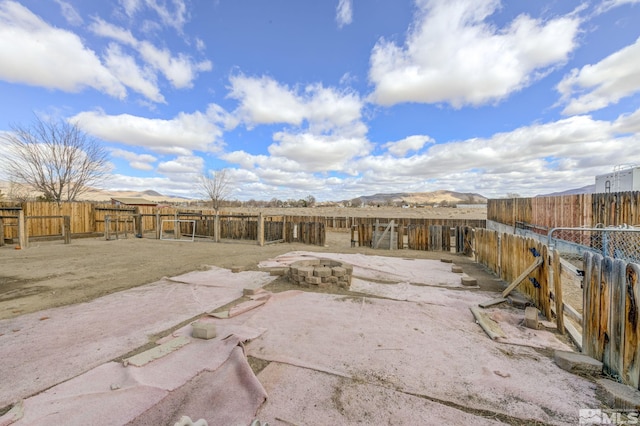 exterior space with a patio area, a mountain view, and a fenced backyard