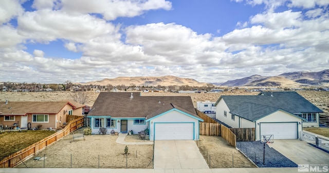 ranch-style home featuring a garage, fence, driveway, and a mountain view