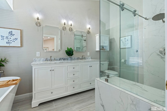 bathroom featuring double vanity, a freestanding bath, a marble finish shower, and a sink