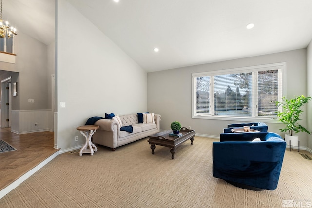 living room featuring recessed lighting, light carpet, a wainscoted wall, a notable chandelier, and baseboards