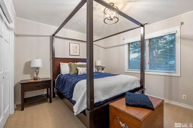 bedroom with light carpet, a textured ceiling, a closet, and an inviting chandelier