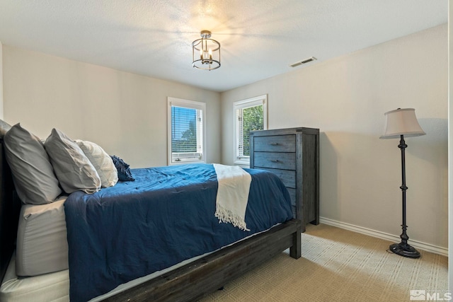 bedroom featuring light carpet, visible vents, and baseboards