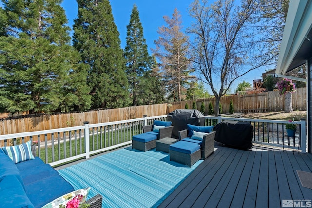 wooden terrace with a fenced backyard and an outdoor living space