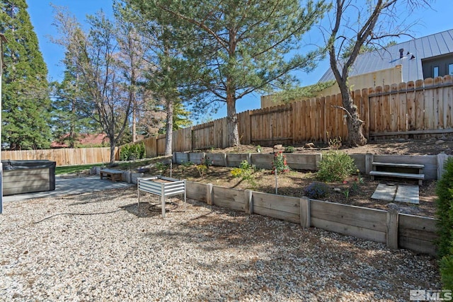 view of yard featuring a hot tub, a vegetable garden, and a fenced backyard