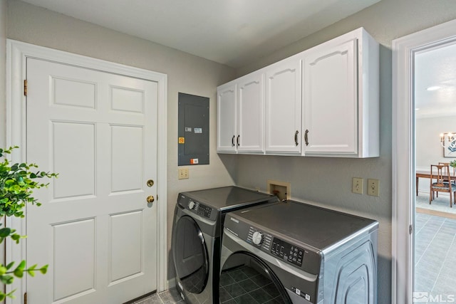 clothes washing area with washer and dryer, electric panel, and cabinet space