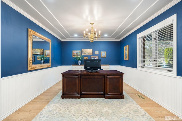 office area with a wainscoted wall, light wood-style flooring, visible vents, and an inviting chandelier
