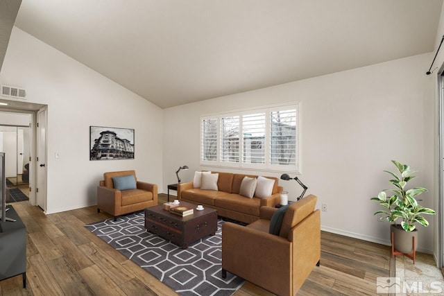 living room with wood finished floors, visible vents, and baseboards