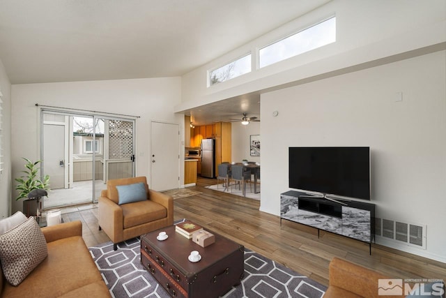 living room featuring high vaulted ceiling, light wood-type flooring, and ceiling fan