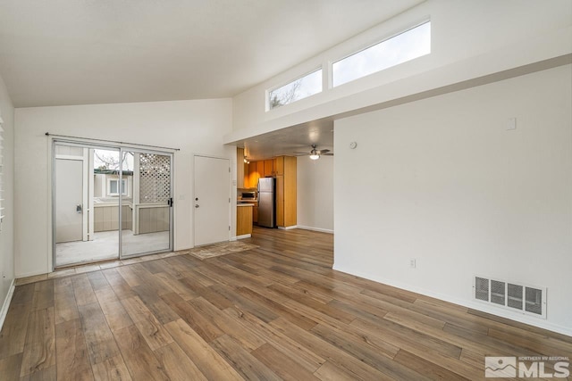 spare room featuring high vaulted ceiling, wood finished floors, a ceiling fan, visible vents, and baseboards