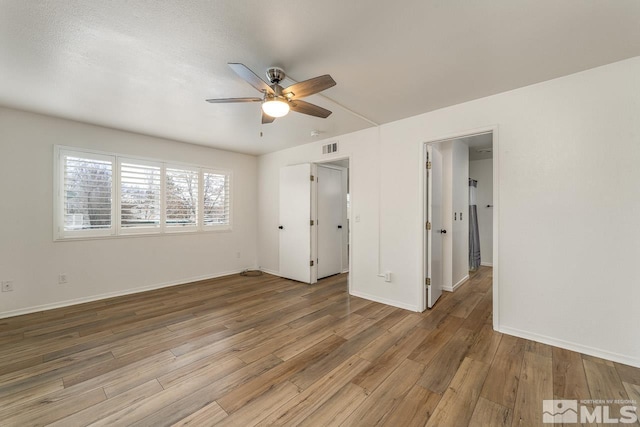 unfurnished bedroom featuring light wood-type flooring, baseboards, visible vents, and ceiling fan