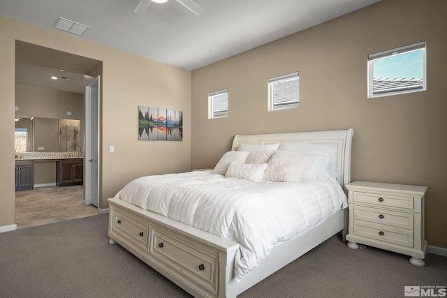 bedroom with connected bathroom, light colored carpet, a ceiling fan, baseboards, and visible vents