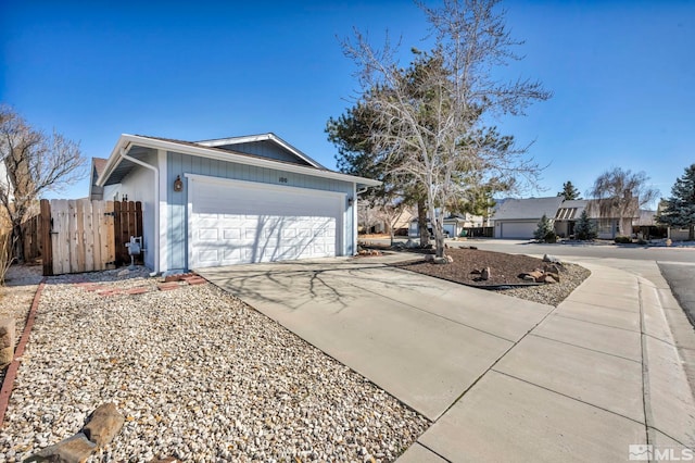 view of property exterior with driveway, an attached garage, and fence