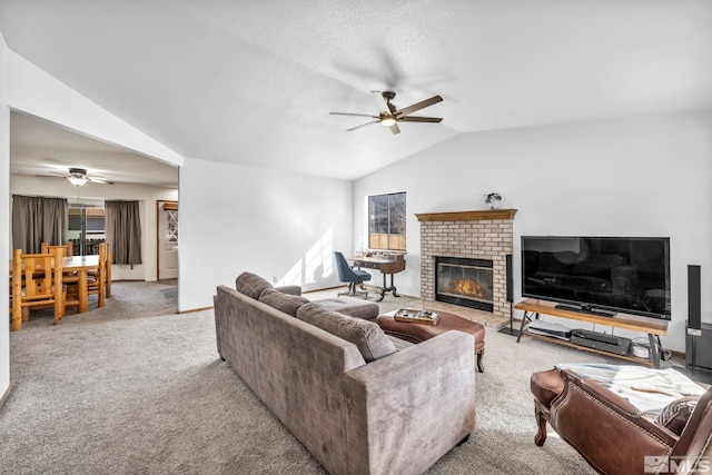 living room featuring lofted ceiling, ceiling fan, carpet floors, and a brick fireplace