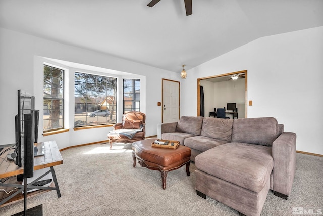 carpeted living area with lofted ceiling, ceiling fan, and baseboards