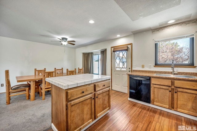 kitchen with dishwasher, tile countertops, light wood-style floors, a sink, and recessed lighting