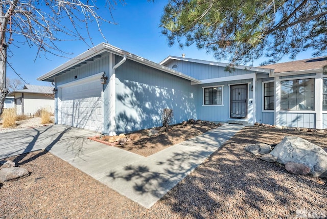 ranch-style house featuring concrete driveway and an attached garage