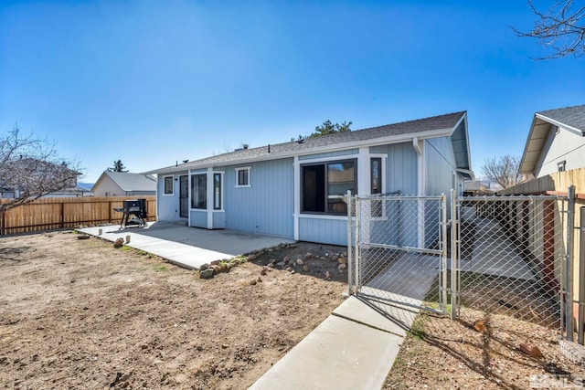 back of house featuring a fenced backyard, a gate, and a patio