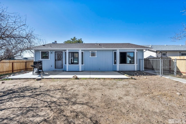 back of property with a fenced backyard and a patio