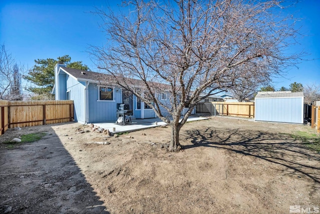 exterior space with a storage shed, a fenced backyard, an outdoor structure, and a patio