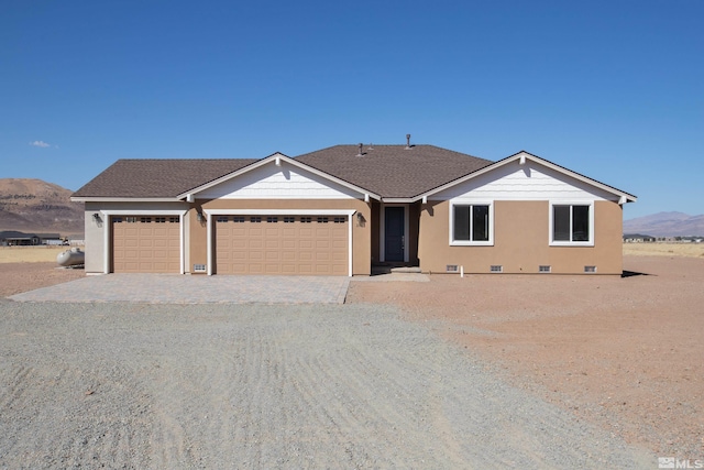 single story home with a garage, roof with shingles, crawl space, decorative driveway, and a mountain view