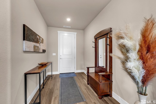 doorway to outside with wood finished floors, visible vents, and baseboards