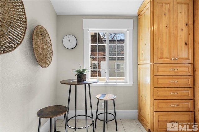 dining room with light tile patterned flooring and baseboards