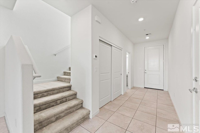 foyer with light tile patterned floors, recessed lighting, visible vents, baseboards, and stairway