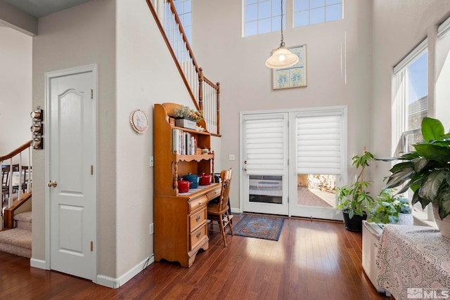 foyer featuring wood-type flooring, baseboards, and stairs