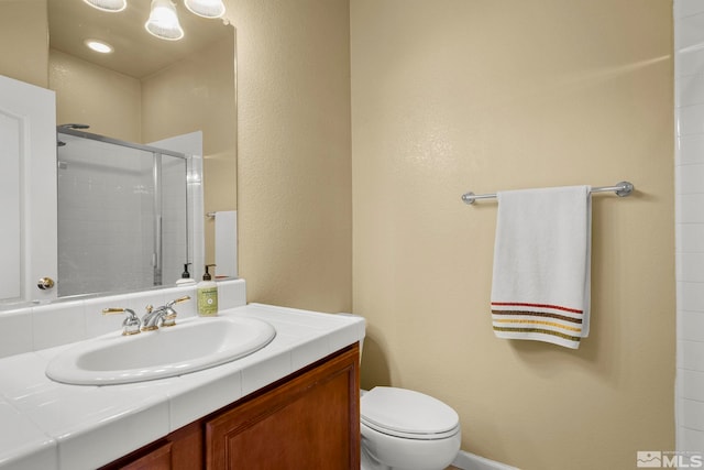 bathroom with a stall shower, vanity, and toilet