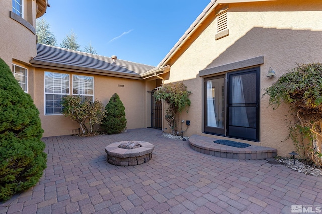 entrance to property with a patio, a tiled roof, and stucco siding