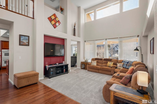 living area featuring wood finished floors, visible vents, and baseboards