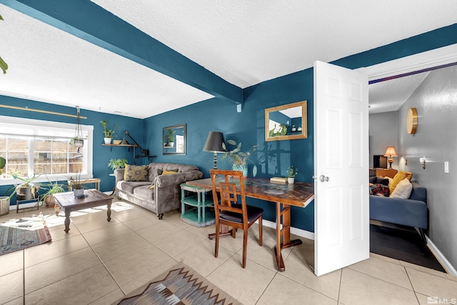 tiled living room with a textured ceiling, beamed ceiling, and baseboards