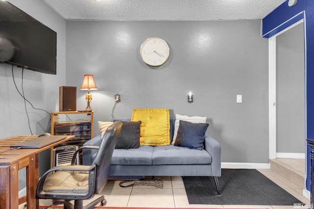 tiled living area featuring a textured ceiling and baseboards