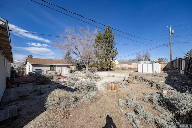 view of yard with an outbuilding, fence, and a storage unit