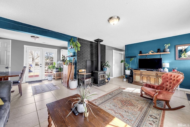 living area featuring a wood stove, light tile patterned floors, a textured ceiling, and french doors