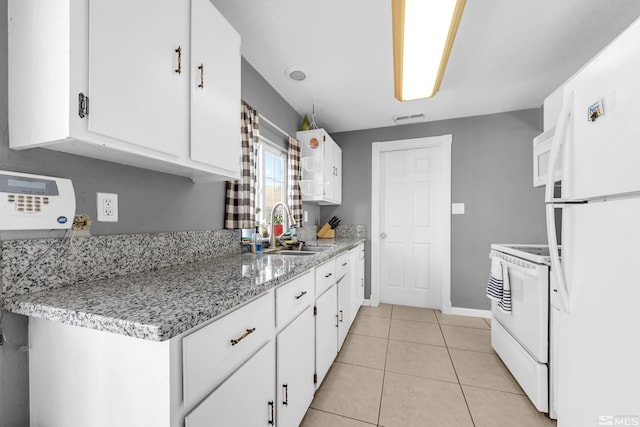 kitchen featuring white appliances, light tile patterned floors, visible vents, white cabinetry, and a sink