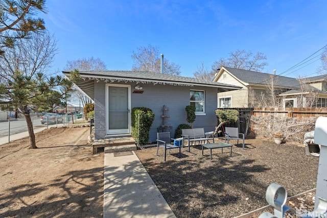 back of property featuring roof with shingles and fence
