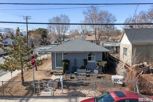 view of front of home featuring roof with shingles, a gate, and a fenced front yard