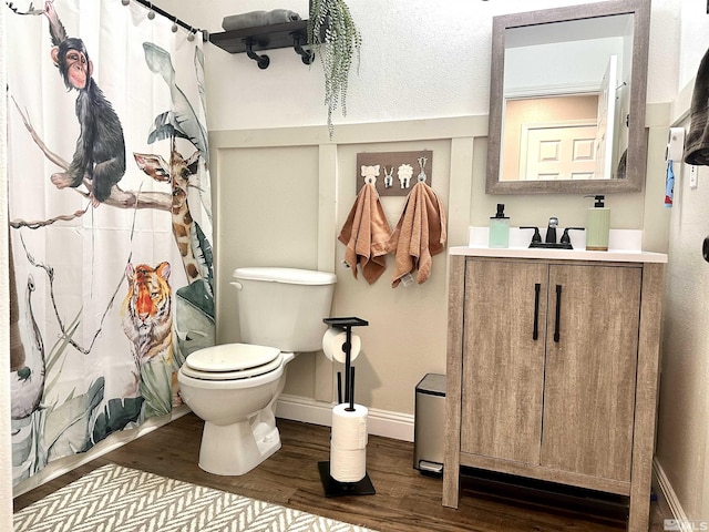 full bath featuring baseboards, toilet, a shower with shower curtain, wood finished floors, and vanity