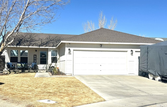 ranch-style house with concrete driveway, an attached garage, and roof with shingles