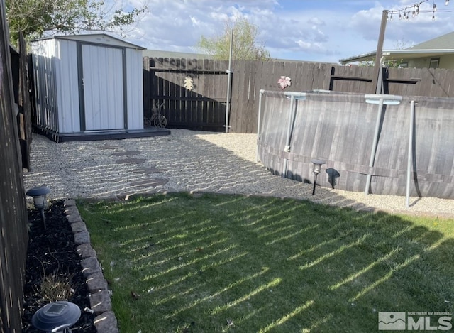 view of yard with an outbuilding, a storage shed, and a fenced backyard