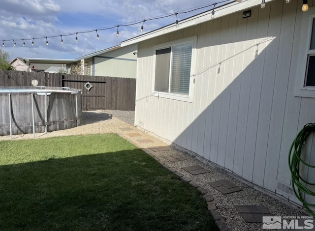 view of yard with a fenced in pool and fence