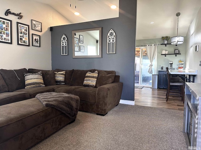 living area featuring baseboards, lofted ceiling, carpet, and a healthy amount of sunlight