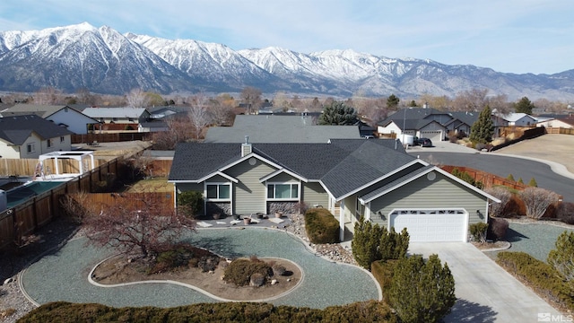 view of front facade with driveway, a shingled roof, a residential view, fence, and a mountain view