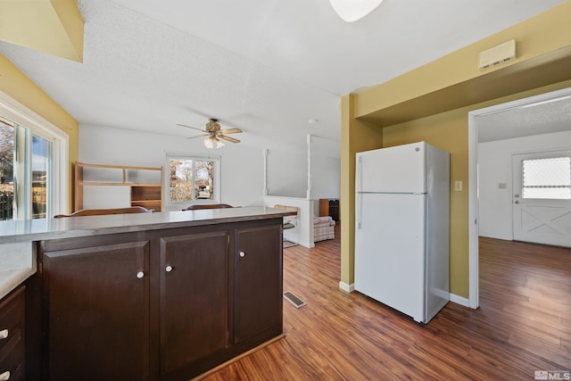 kitchen with dark brown cabinets, freestanding refrigerator, and a healthy amount of sunlight